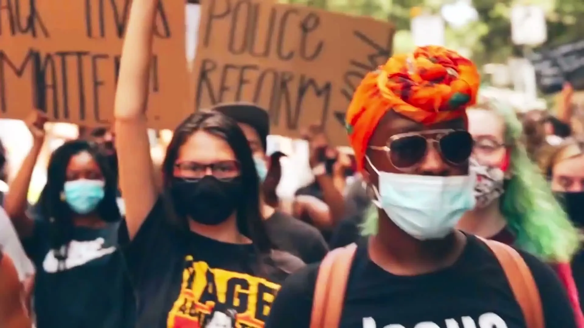 A still from Never Again: marchers in Atlanta carrying signs reading Black Lives Matter and Police Reform.